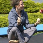 Cheryl sitting in meditation position bouncing on trampoline