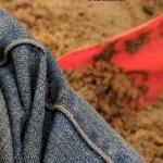 closeup of jeans pant leg on sand