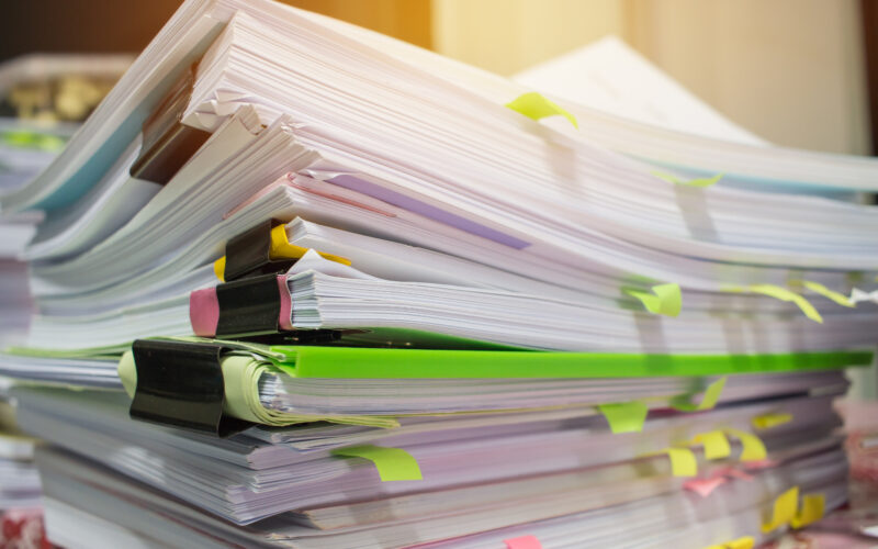 stacks of computer paper clipped together by bulldog clips